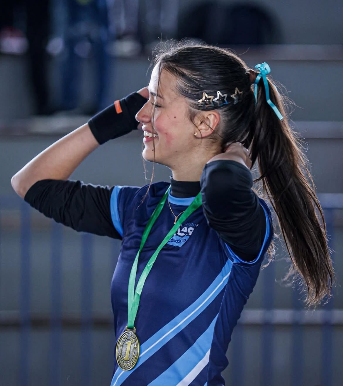 Antonella sorrindo com medalha de primeiro lugar