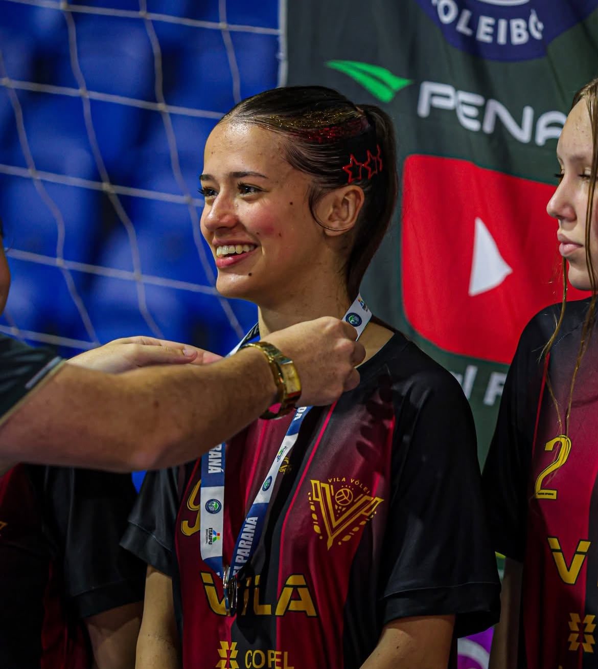 Antonella sorrindo ao receber medalha com a camisa 9 do Vila Vôlei